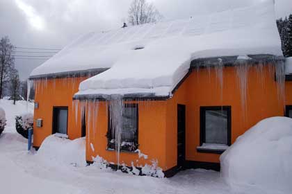 Orangefarbiges Haus mit Eiszapfenborte